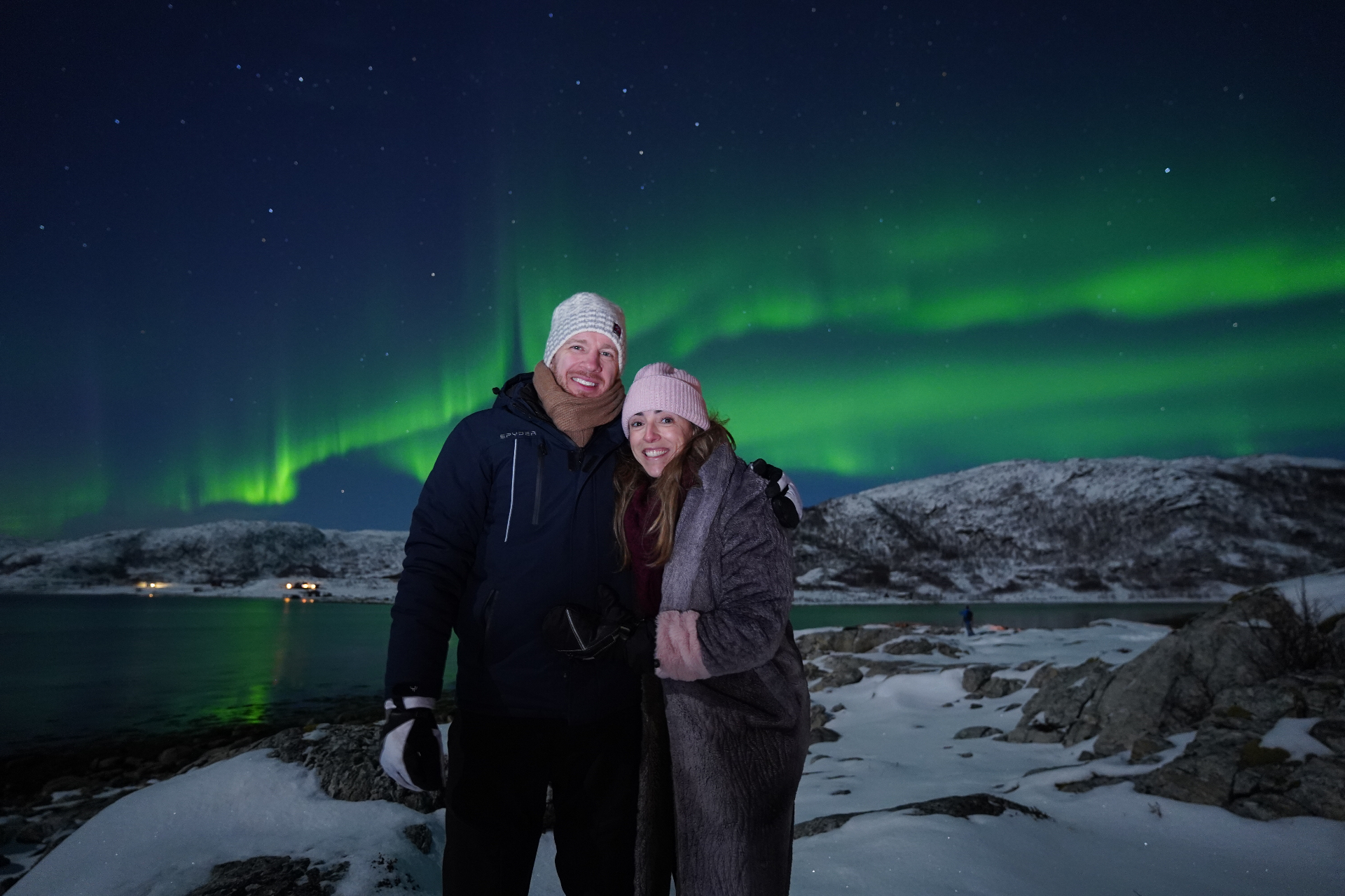 Northern lights dancing over a Tromsø fjord